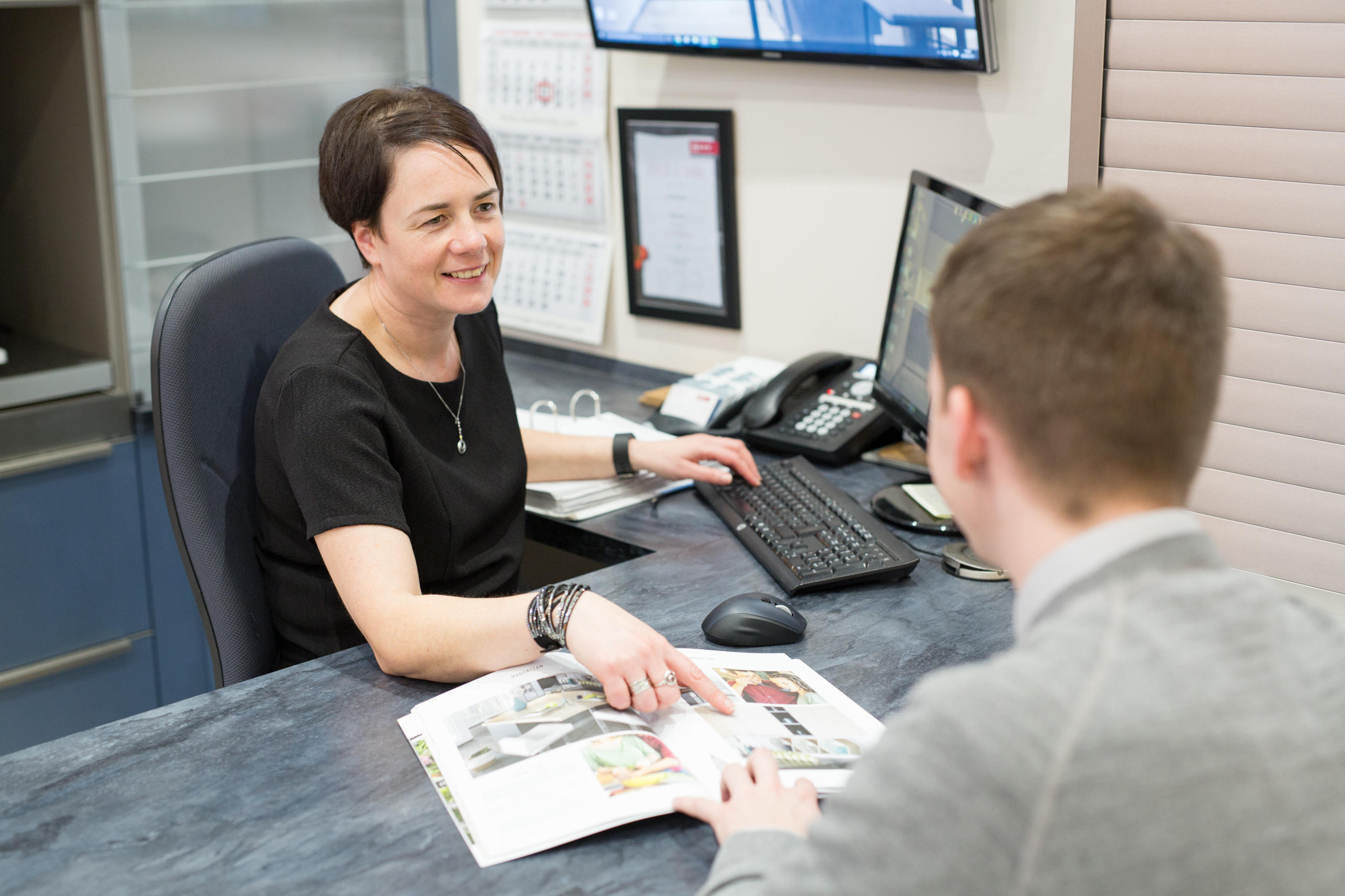 Two members of the James Donaldson Group team conversing at a desk