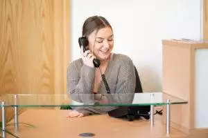 A staffmember of James Donaldson Group at her desk answering a phone