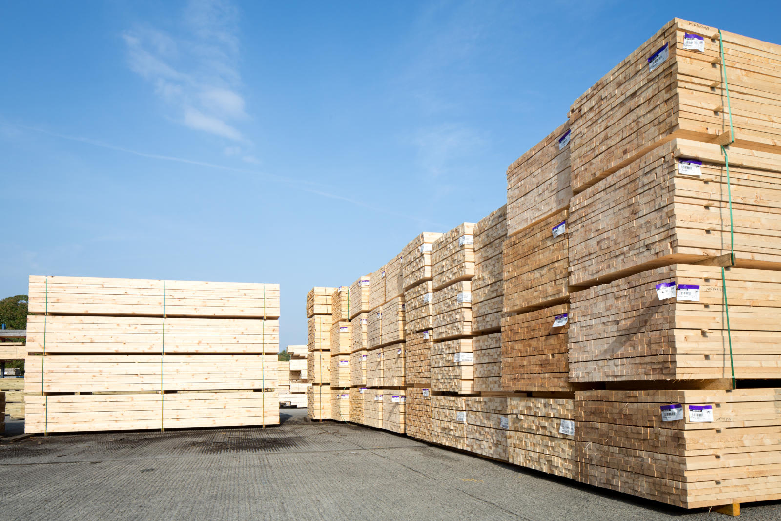 Neatly stacked wooden products sitting in a concrete yard